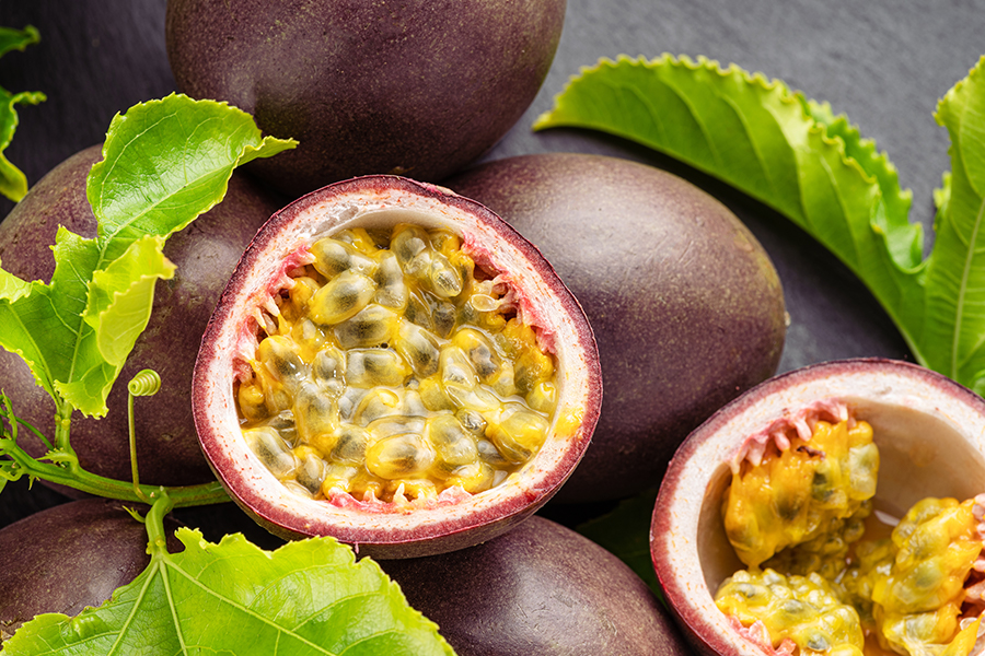 Frutto della Passione Maracuja intero e tagliato: semi e polpa gialla ricca di proprietà